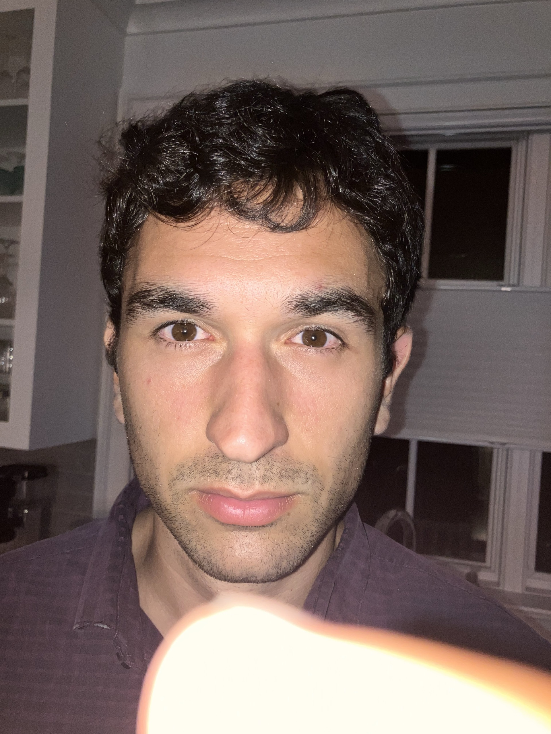 Close-up portrait with a fingertip in the foreground